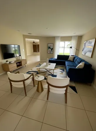 a living room with furniture a flat screen tv and a window