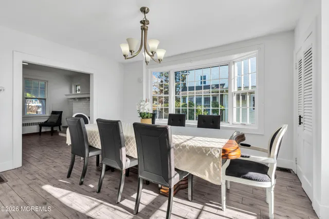 a view of a dining room with furniture a chandelier and wooden floor