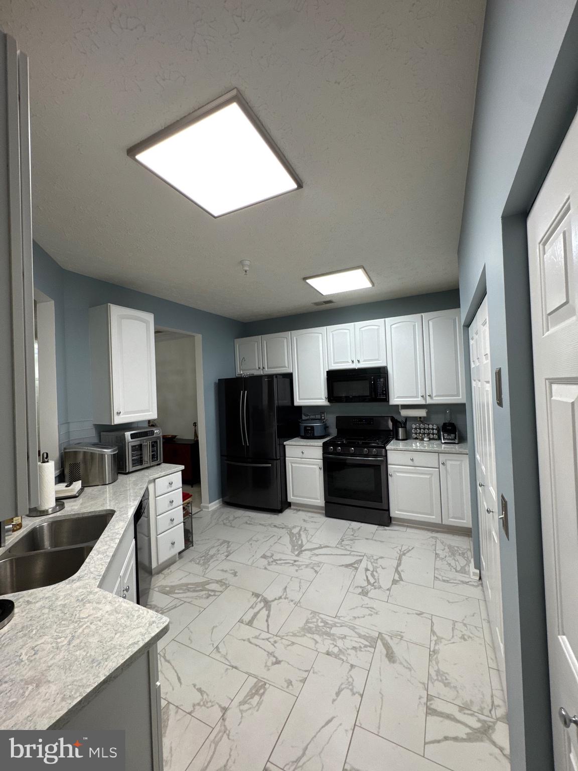 5144 Brightleaf Court, Unit 5144 Rosedale, MD 21237 - Photo 10 of 47 a kitchen with stainless steel appliances a stove a sink a microwave a refrigerator and cabinets