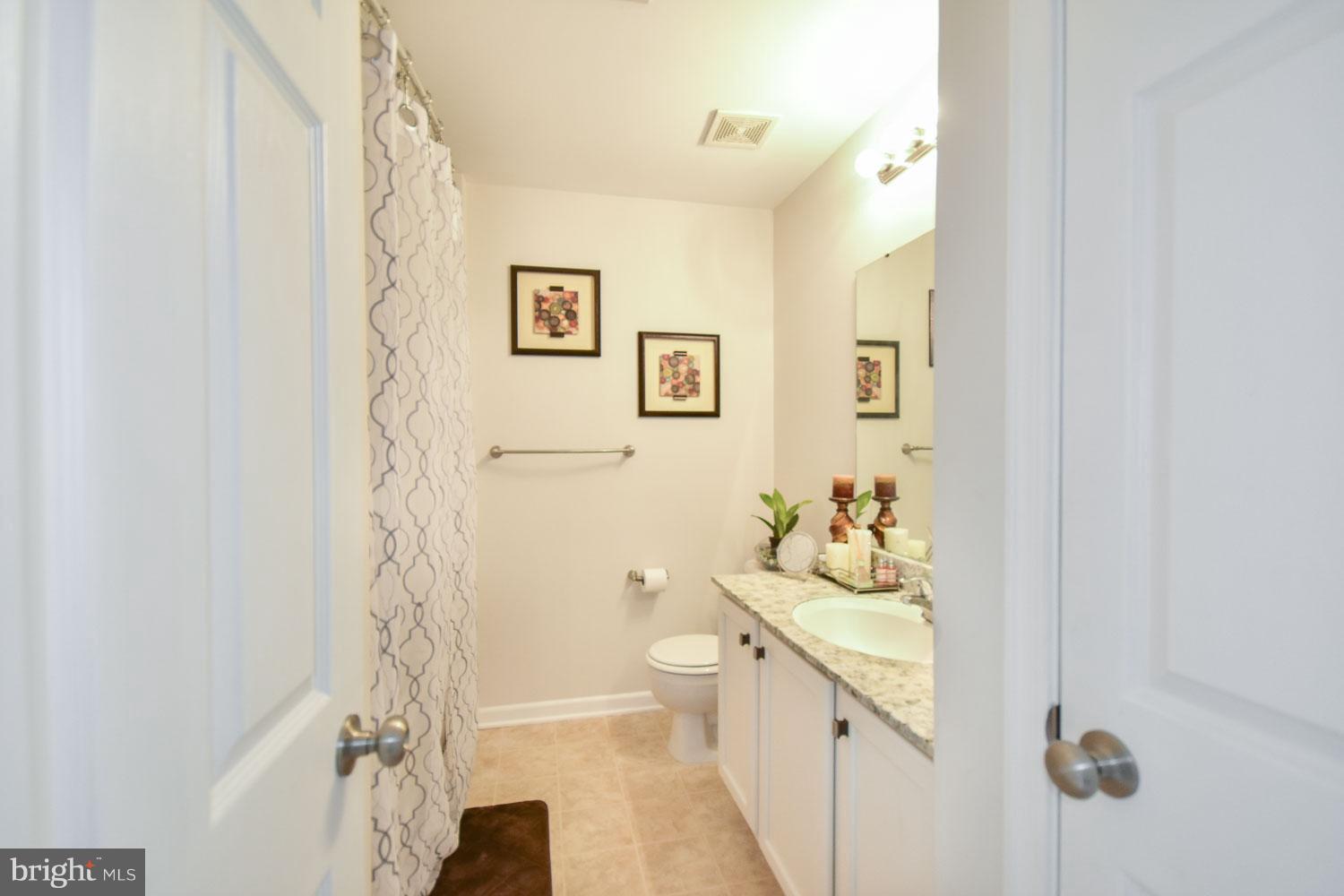 1240 Steed Street Ranson, WV 25438 - Photo 16 of 30 a bathroom with a sink a toilet and shower curtain