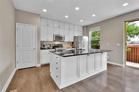 a kitchen with stainless steel appliances granite countertop a stove a sink a refrigerator and a microwave