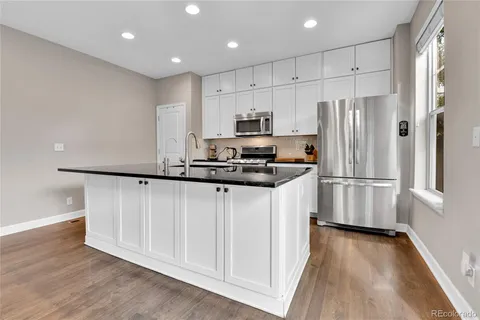 a kitchen with stainless steel appliances a refrigerator and a stove top oven