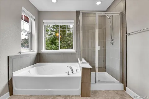 a white bath tub sitting in a bathroom next to a window