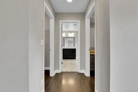 a view of a hallway with wooden floor and staircase