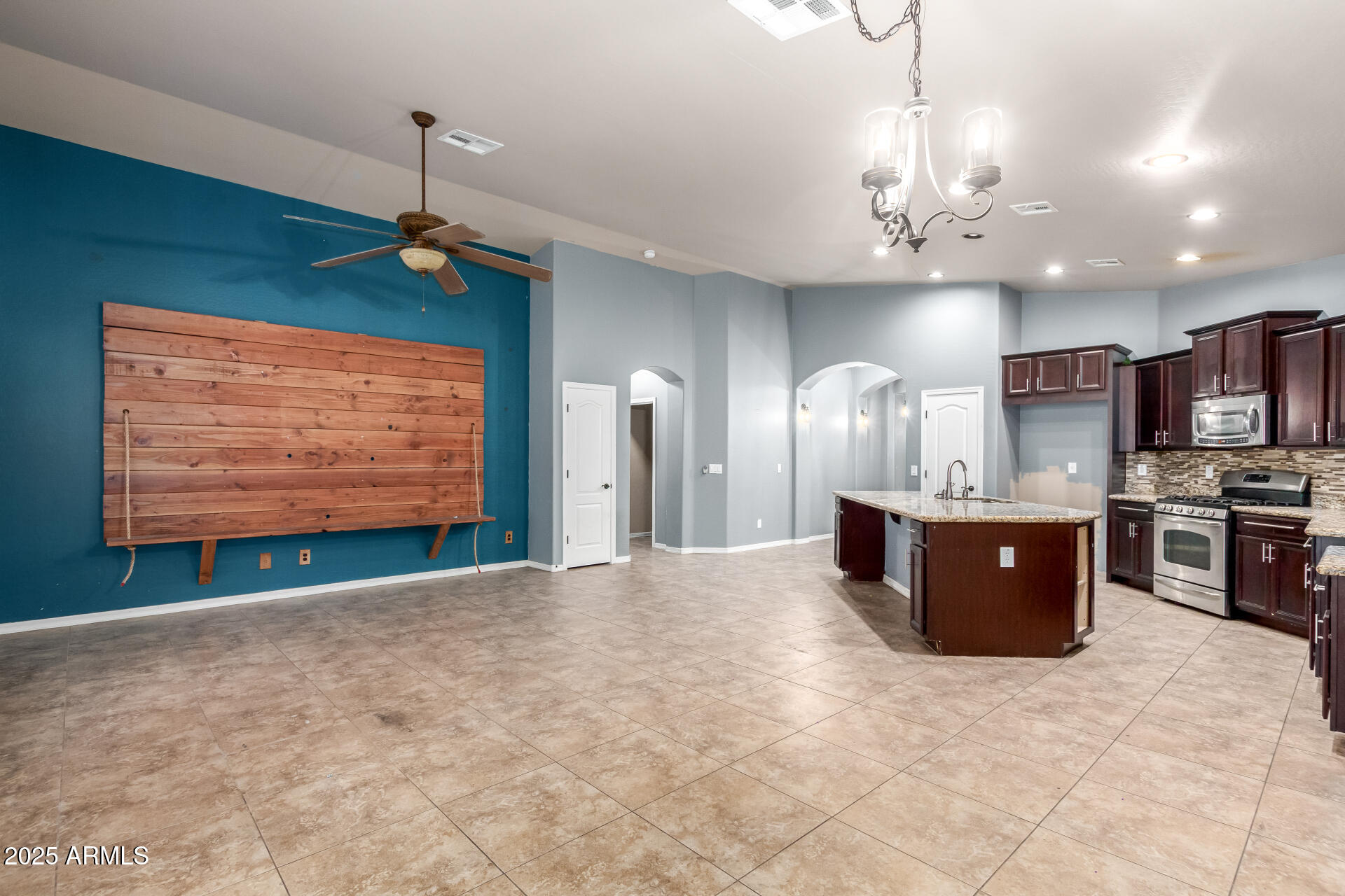 20768 West Hamilton Street Buckeye, AZ 85396 - Photo 11 of 33 a living room with stainless steel appliances furniture a chandelier and a flat screen tv
