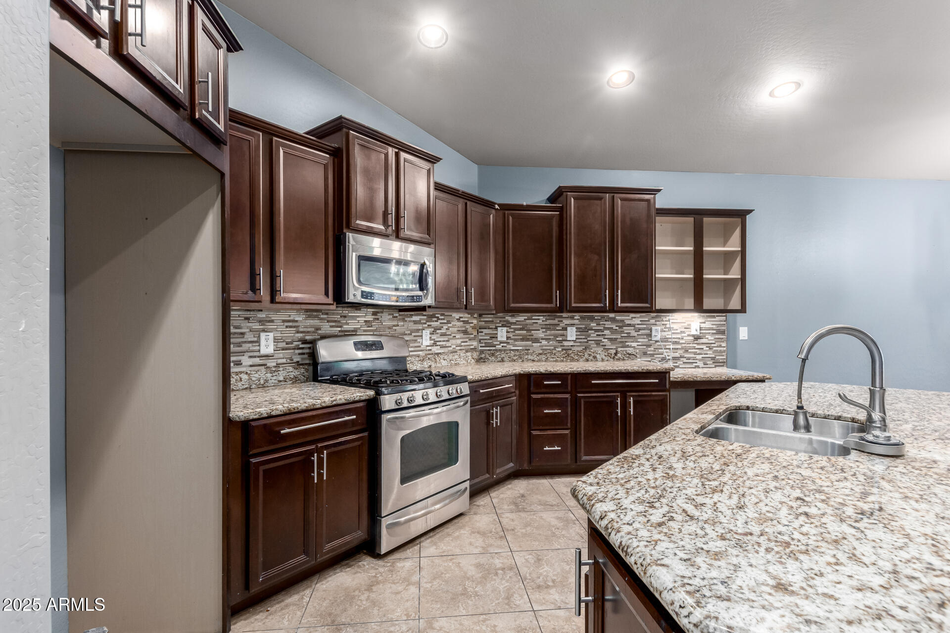 20768 West Hamilton Street Buckeye, AZ 85396 - Photo 13 of 33 a kitchen with stainless steel appliances granite countertop a stove sink and cabinets