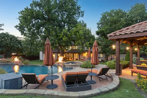 a view of a swimming pool with lawn chairs and a big yard