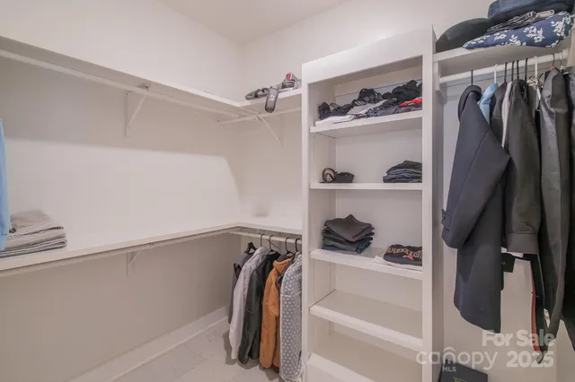 a view of walk in closet with clothes and shoes
