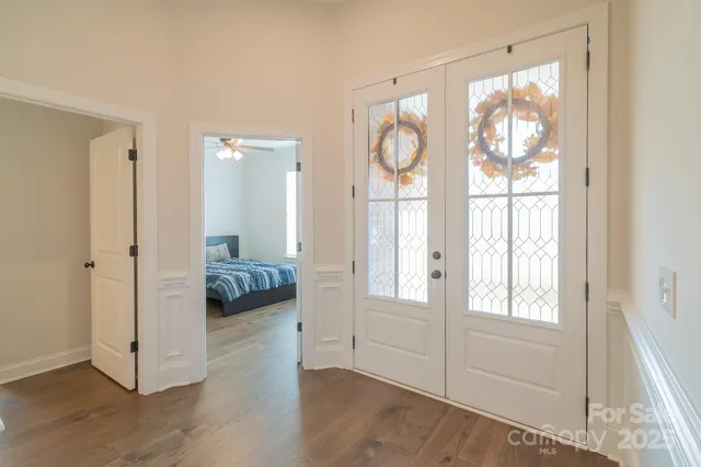 a view of a bedroom with wooden floor and windows
