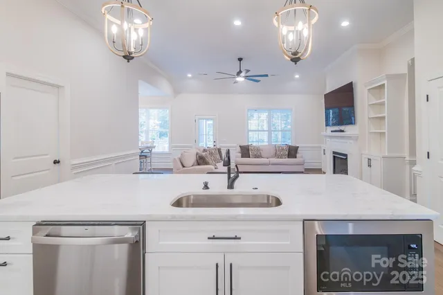 a view of a kitchen island a chandelier furniture and fireplace