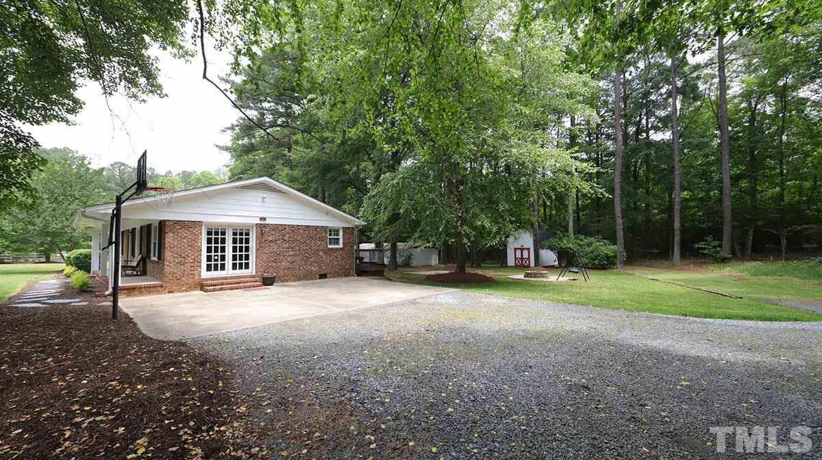 3421 Coley Road Durham, NC 27703 - Photo 3 of 30 Long, gravel driveway leads to a large parking pad with a side entrance to the home.