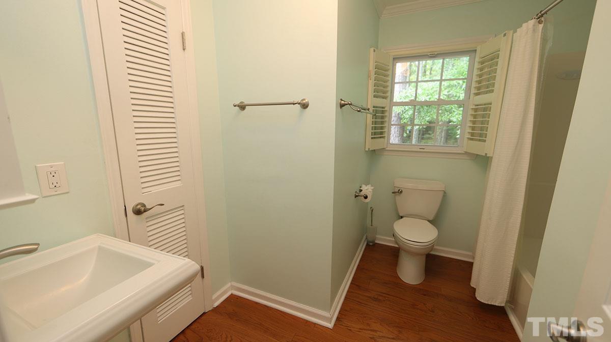 3421 Coley Road Durham, NC 27703 - Photo 21 of 30 Pedestal sink, hardwoods, tub/shower combo and a linen closet.