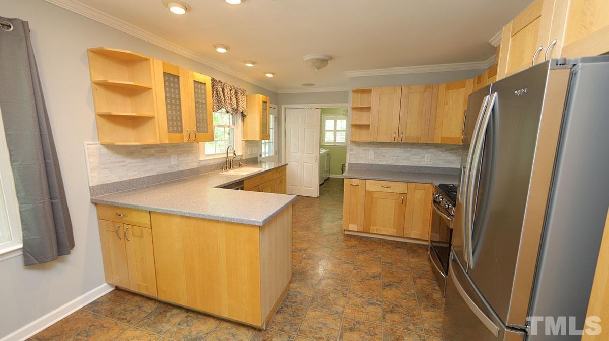 3421 Coley Road Durham, NC 27703 - Photo 10 of 30 Remodeled kitchen with maple, craftsman style cabinets, solid surface counters, marble backsplash. New stainless appliances in 2019 include gas range, dishwasher, low profile microwave and fridge.