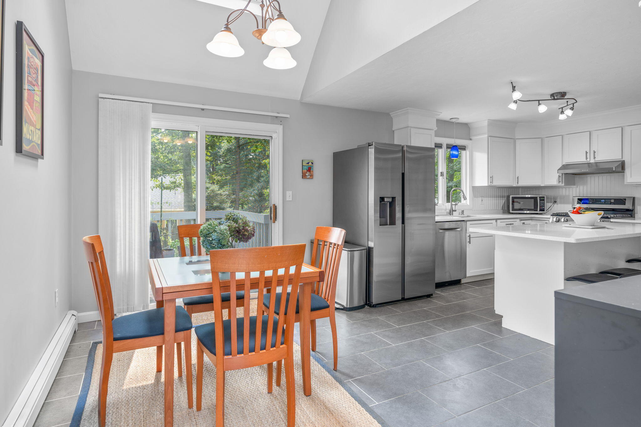 104 Pond Circle Mashpee, MA 02649 - Photo 19 of 29 a kitchen with stainless steel appliances a refrigerator a stove a dining table and chairs