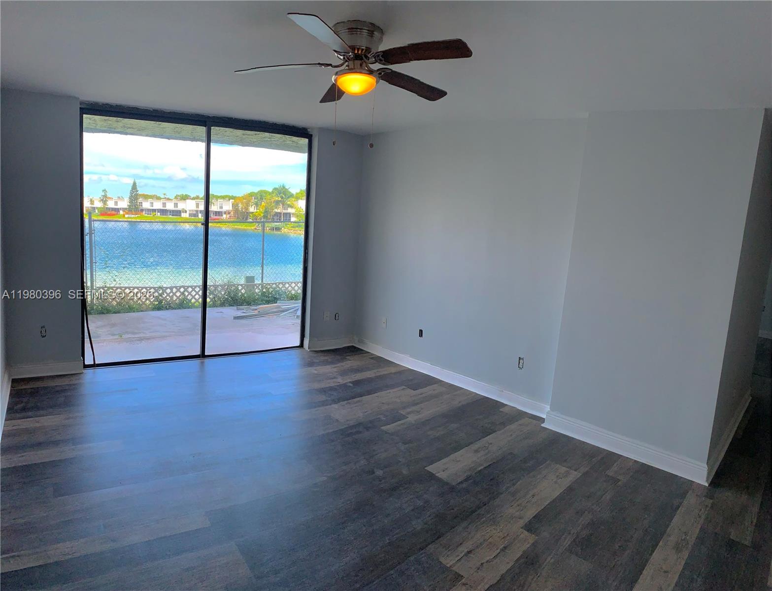 8307 Southwest 142nd Avenue, Unit E112 Miami, FL 33183 - Photo 1 of 12 an empty room with wooden floor and windows