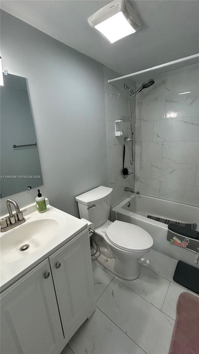 8307 Southwest 142nd Avenue, Unit E112 Miami, FL 33183 - Photo 7 of 12 a bathroom with a toilet sink and mirror