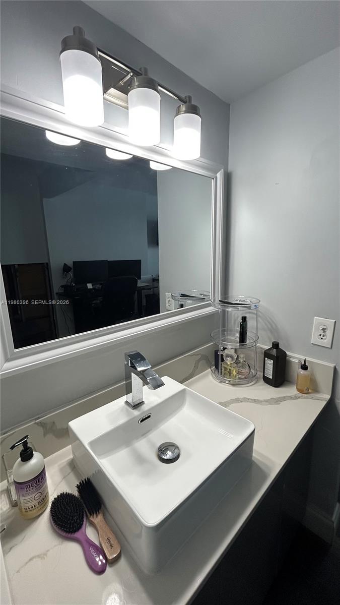 8307 Southwest 142nd Avenue, Unit E112 Miami, FL 33183 - Photo 8 of 12 a bathroom with a sink and a mirror