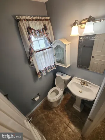 a bathroom with a toilet a sink and mirror