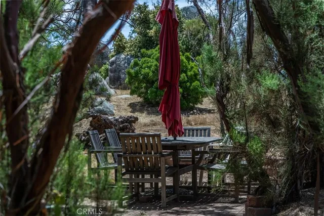 a view of a backyard with table and chairs and wooden fence