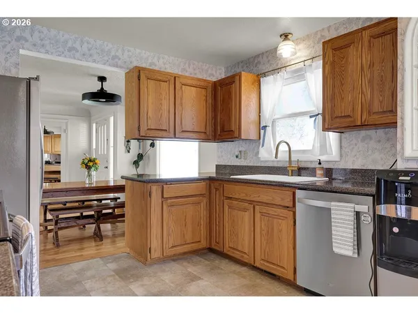 a kitchen with kitchen island granite countertop a sink cabinets and wooden floor