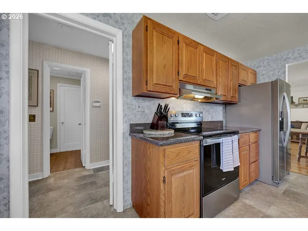 a kitchen with stainless steel appliances granite countertop a refrigerator a stove a sink and dishwasher