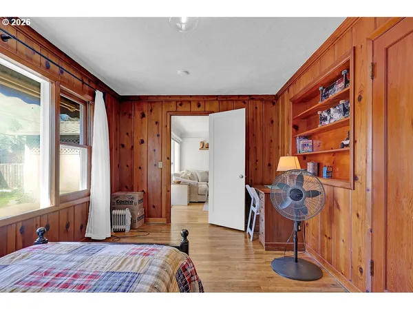 a bedroom with a bed and large windows