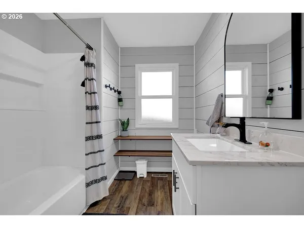 a bathroom with a bathtub shower sink vanity and a toilet