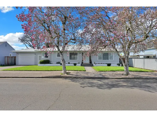 a view of a house with a big yard and large trees