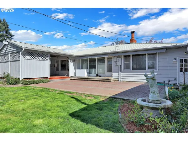 a front view of a house with a yard and potted plants