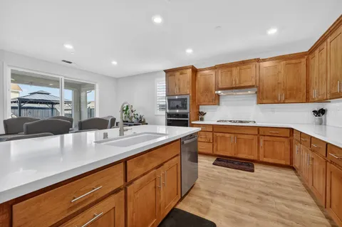 a kitchen with kitchen island granite countertop a sink counter top space and cabinets