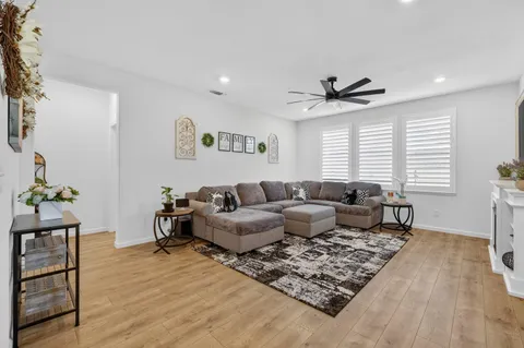 a living room with furniture kitchen view and a large window