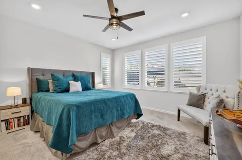 a bedroom with a bed a chandelier and a window