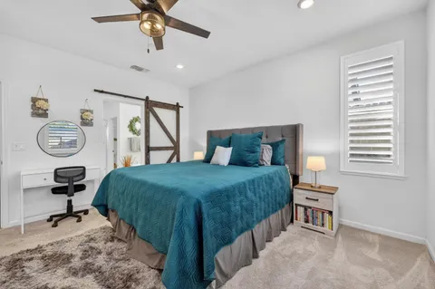 a bedroom with a bed a window and a flat screen television