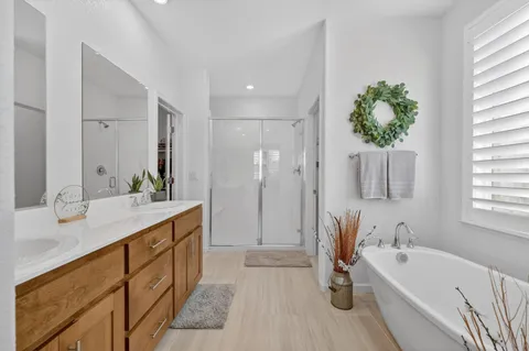 a spacious bathroom with a double vanity sink a mirror and a bathtub