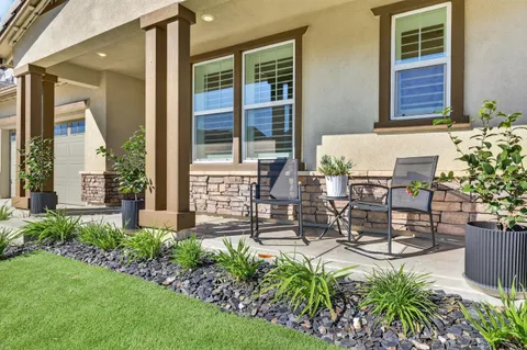 a view of a patio with table and chairs and potted plants