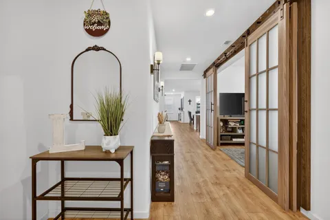a view of a hallway with a flat screen tv and a potted plant