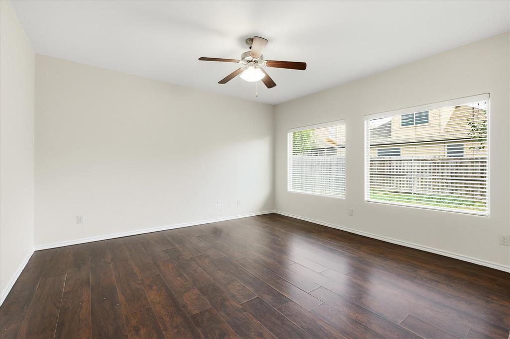 720 Rio Bravo Drive Fort Worth, TX 76052 - Photo 11 of 38 Spacious room featuring dark wood-finish flooring, light-toned walls, and a ceiling fan with integrated lighting