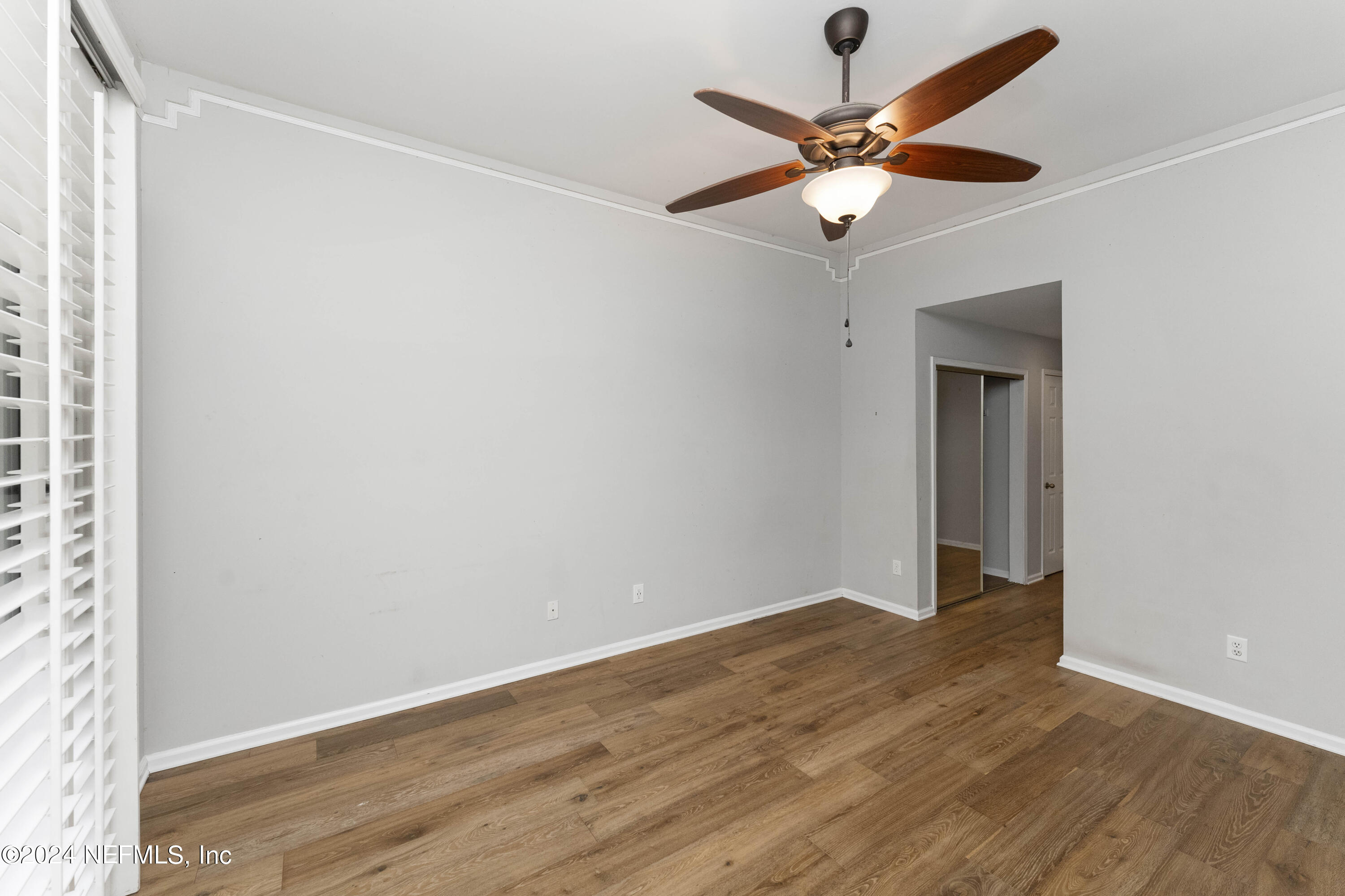 587 Selva Lakes Circle Atlantic Beach, FL 32233 - Photo 13 of 31 an empty room with wooden floor and ceiling fan