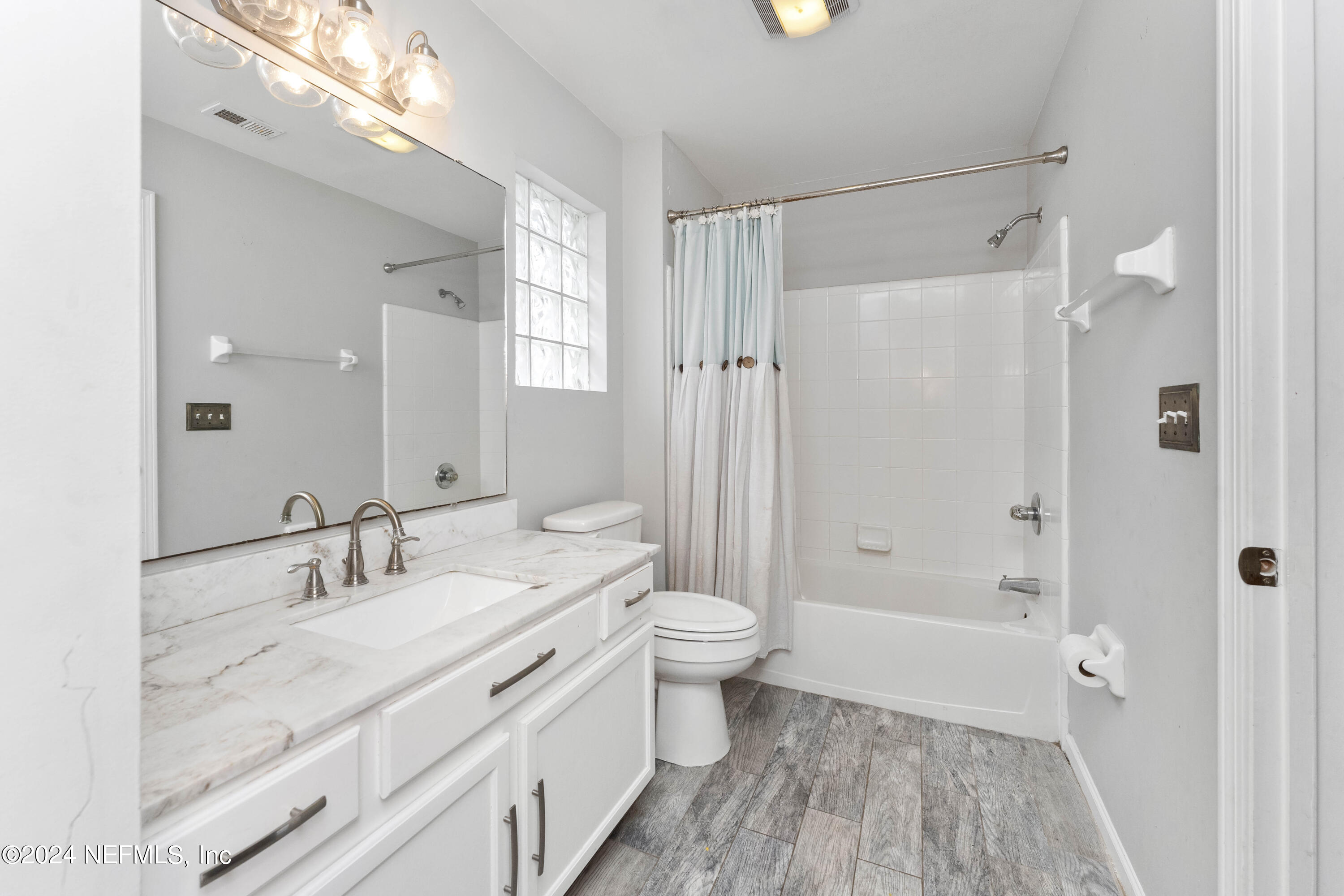 587 Selva Lakes Circle Atlantic Beach, FL 32233 - Photo 19 of 31 a bathroom with a granite countertop sink a toilet a shower and a mirror