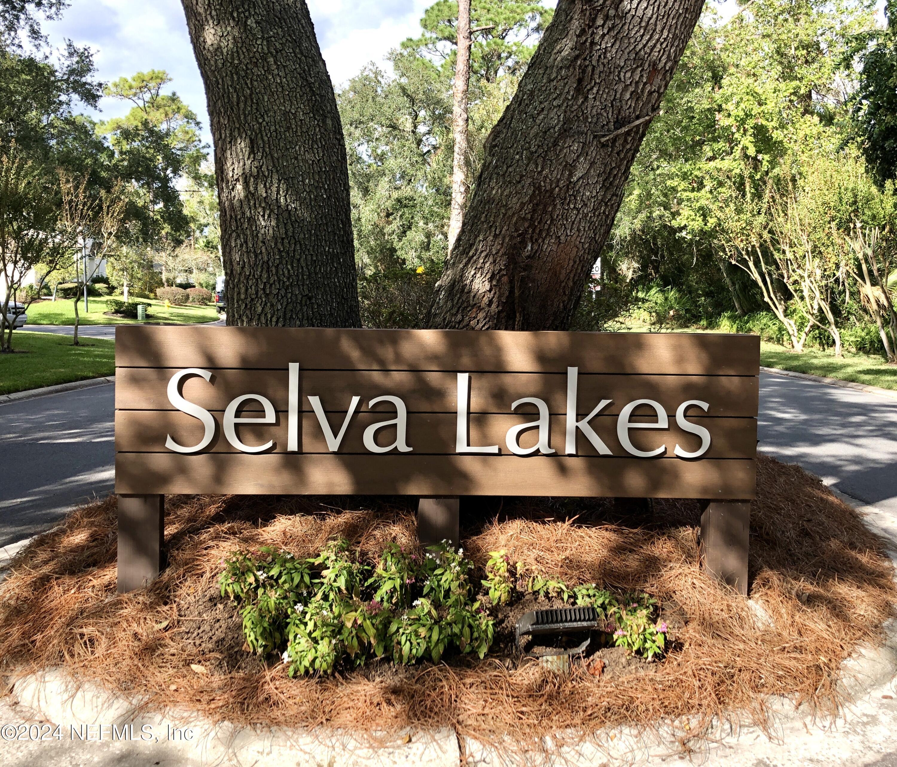 587 Selva Lakes Circle Atlantic Beach, FL 32233 - Photo 29 of 31 a street sign that is sitting on a wooden bench