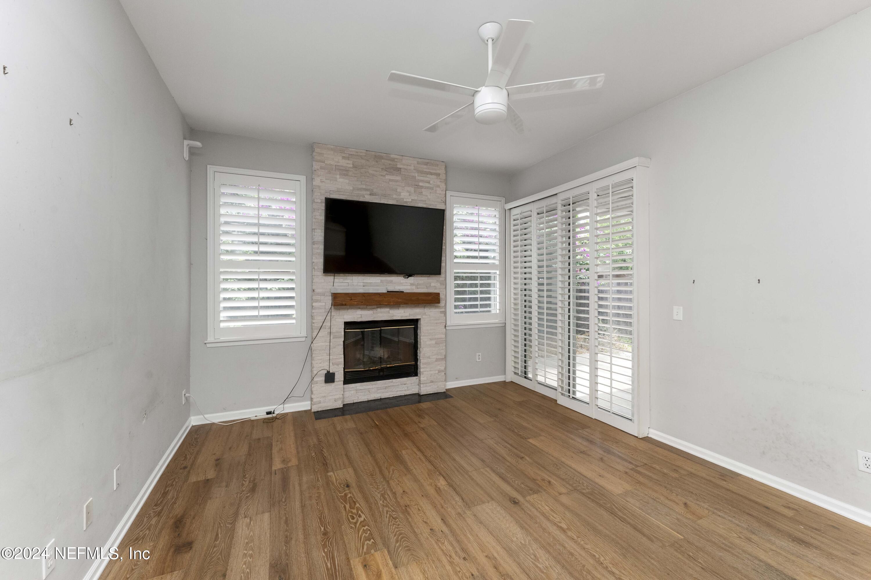 587 Selva Lakes Circle Atlantic Beach, FL 32233 - Photo 3 of 31 a view of empty room with wooden floor fireplace and a window