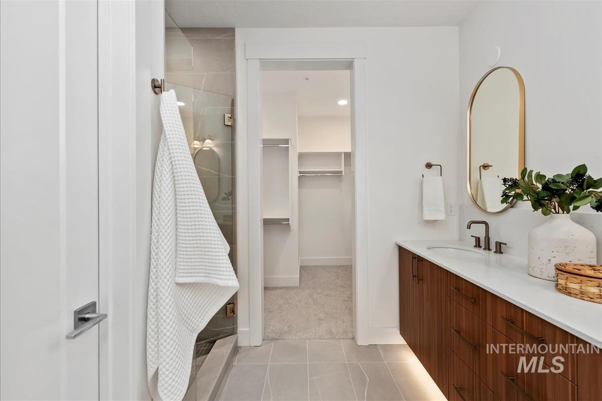3243 West Moore Street Boise, ID 83702 - Photo 19 of 38 Bathroom with vanity, light tile patterned floors, a spacious closet, and a shower stall