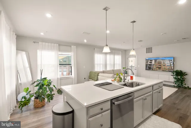 a kitchen with a sink a counter and chairs