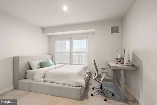 a bedroom with a bed a table and chair