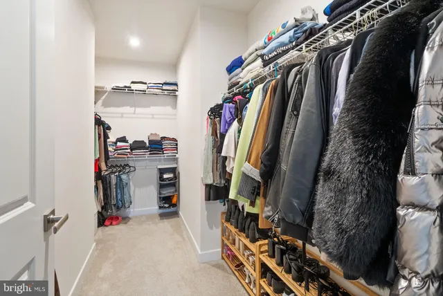 a view of walk in closet with clothes and shoes