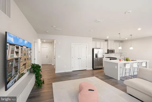 a large white kitchen with stainless steel appliances granite countertop a refrigerator and a stove top oven