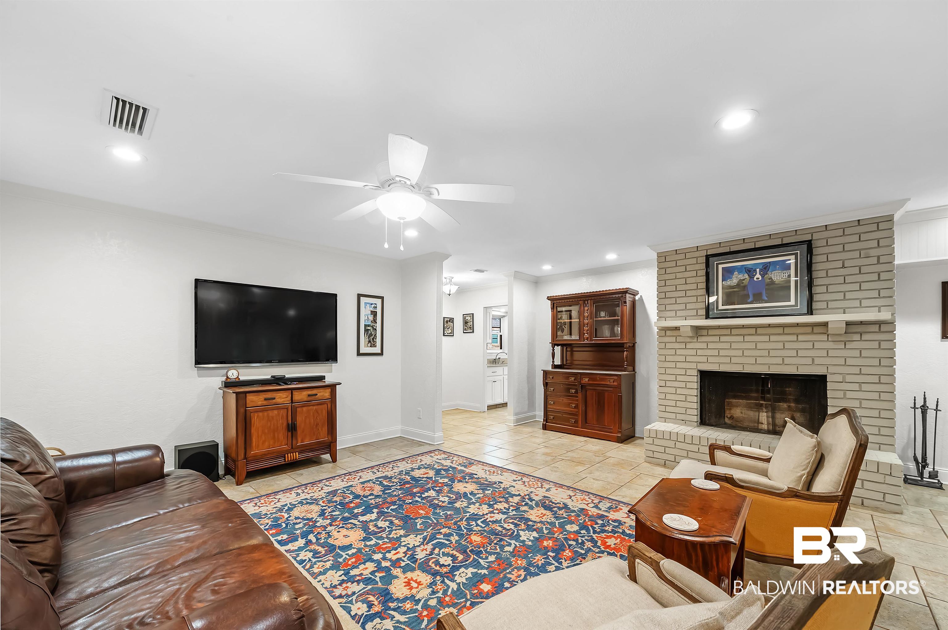 104 James Circle Daphne, AL 36526 - Photo 30 of 62 Living room featuring brick wall, a fireplace, ceiling fan, and light tile patterned floors