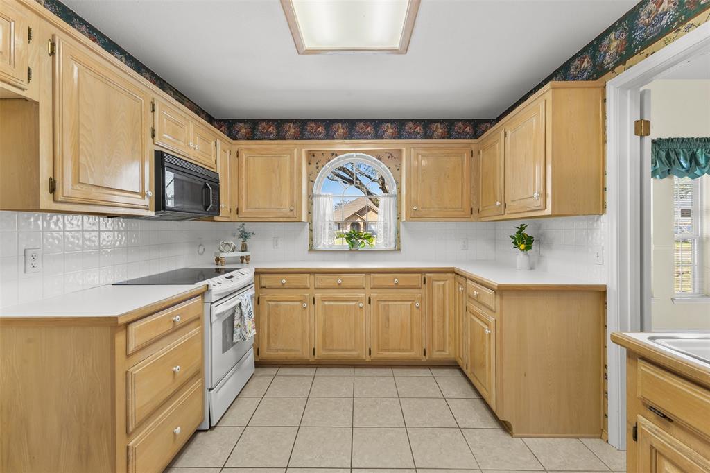 1516 Ryan Road Sulphur Springs, TX 75482 - Photo 12 of 37 a kitchen with stainless steel appliances granite countertop a sink stove and cabinets