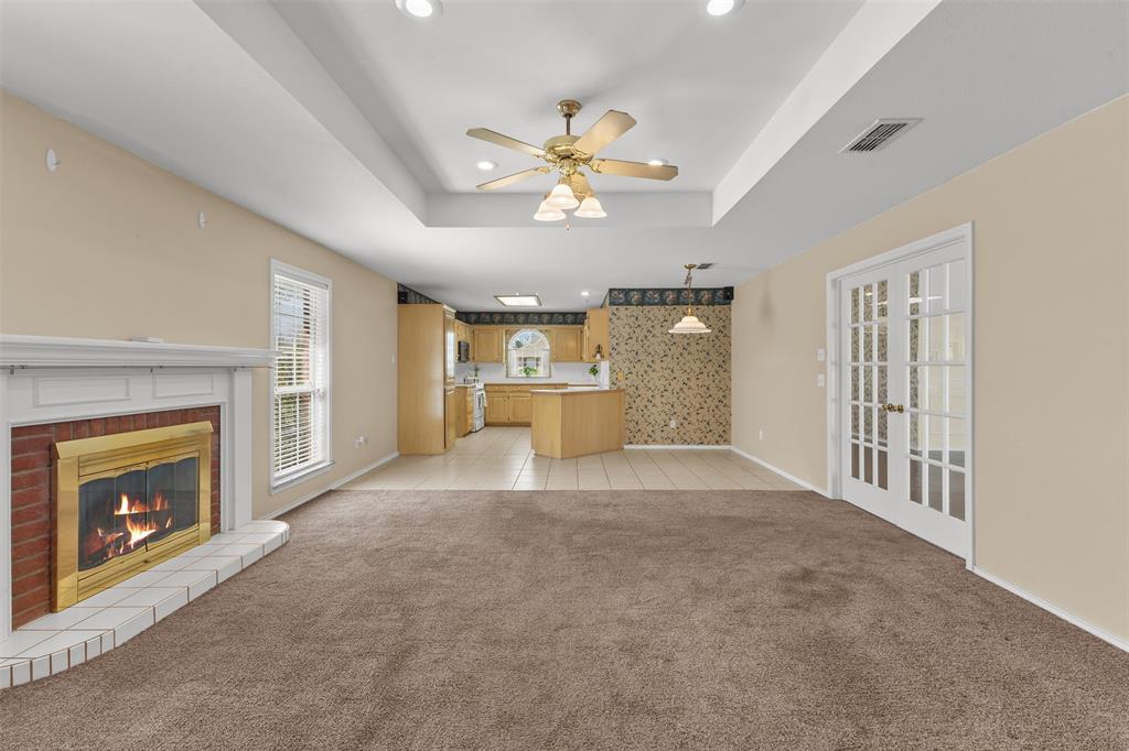 1516 Ryan Road Sulphur Springs, TX 75482 - Photo 9 of 37 a view of a livingroom with a fireplace a ceiling fan windows and chandelier