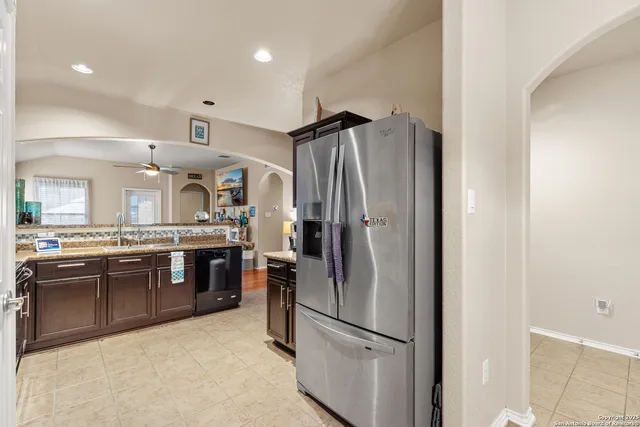 a kitchen with stainless steel appliances granite countertop a refrigerator stove and sink
